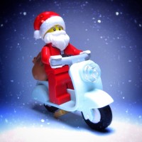 Санта с мешком за спиной едет на мопеде из Лего