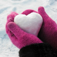 Руки в розовых перчатках держат снежок в форме сердца