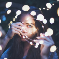 Девушка смотрит в спираль со светящимися лампочками