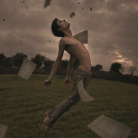 Мужчина в прыжке в окружении падающих листков бумаги.