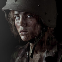 Девушка с грязным лицом в военной каске.