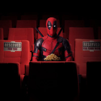 Дэдпул с ведром попкорна сидит в кинотеатре