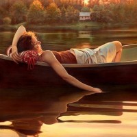 Девушка лежит в лодке опустив руку в воду.