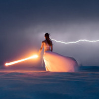 Девушка в белом платье стоит со светящейся палкой на фоне молний
