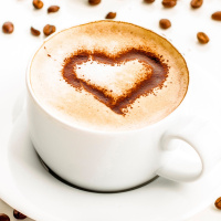 Белая кружка кофе с коричневым сердечком на пенке