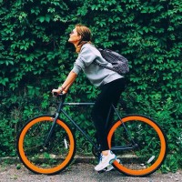 Девушка на велосипеде с оранжевыми колёсами