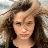 Девушка с веснушками и растрёпанными ветром волосами