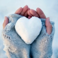 Снежок в форме сердца на руках девушки.